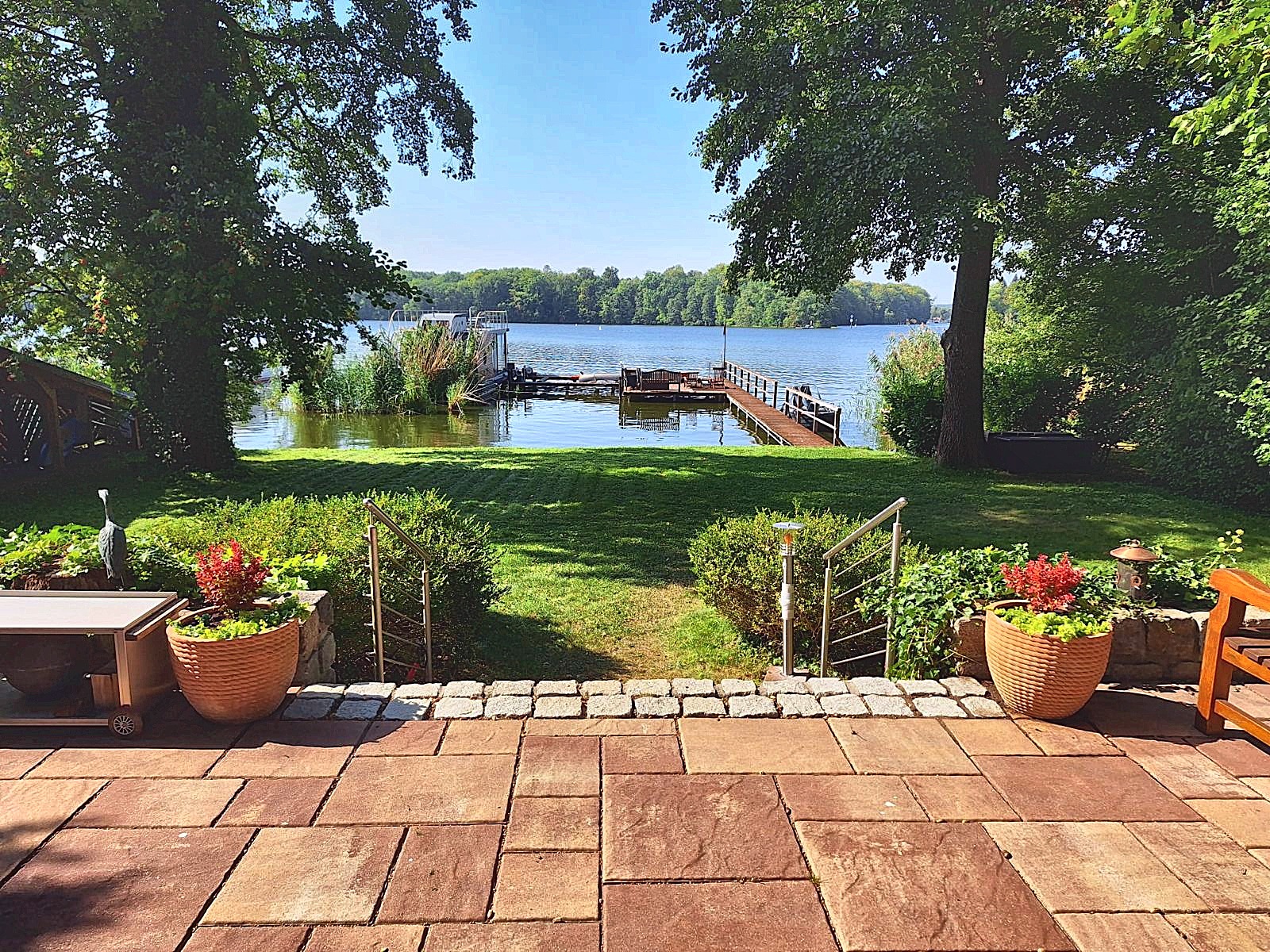 Blick von der Terrasse über den Garten auf den Steg am Krüpelsee