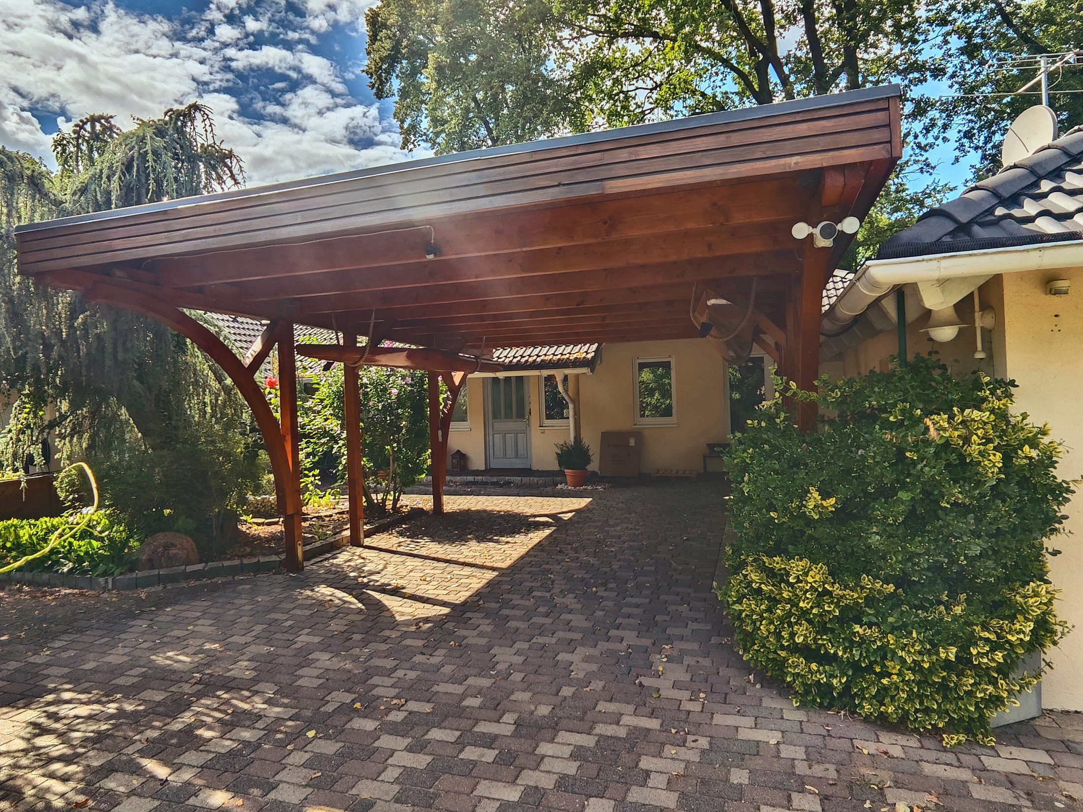 Holz-Carport über der gepflasterten Zufahrt am Hauseingang des Anwesens in Senzig