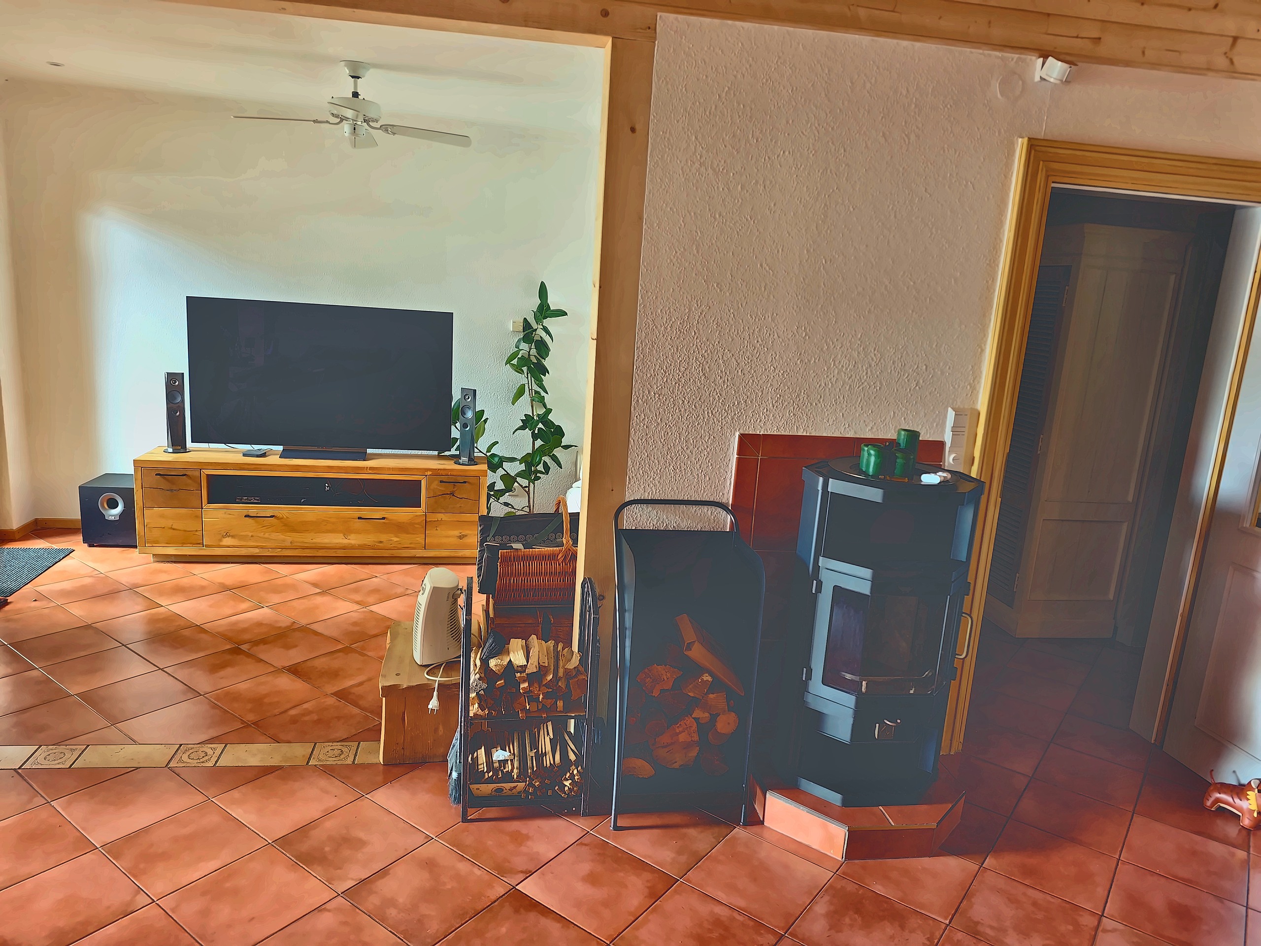 Wohnzimmer mit Kaminofen und Terrakottaboden im Haus in Senzig