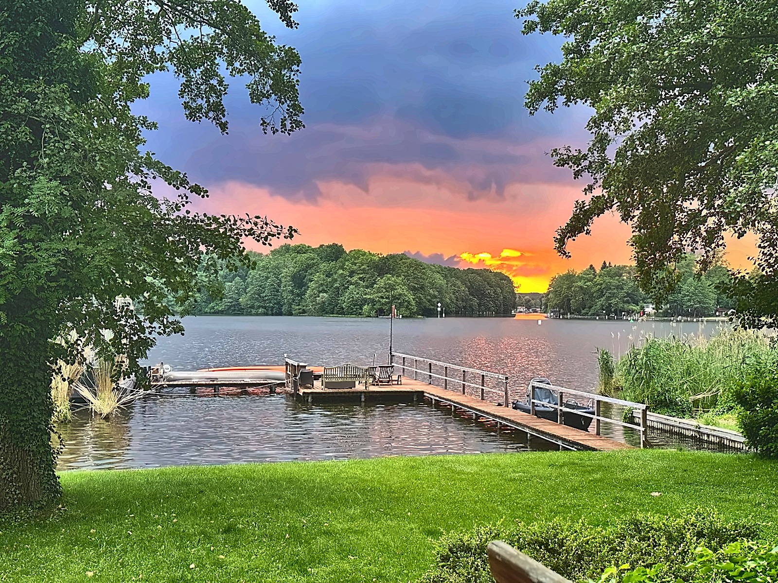 Eigener Holzsteg am Krüpelsee in Senzig im Abendlicht, von Rasenfläche und Bäumen eingerahmt