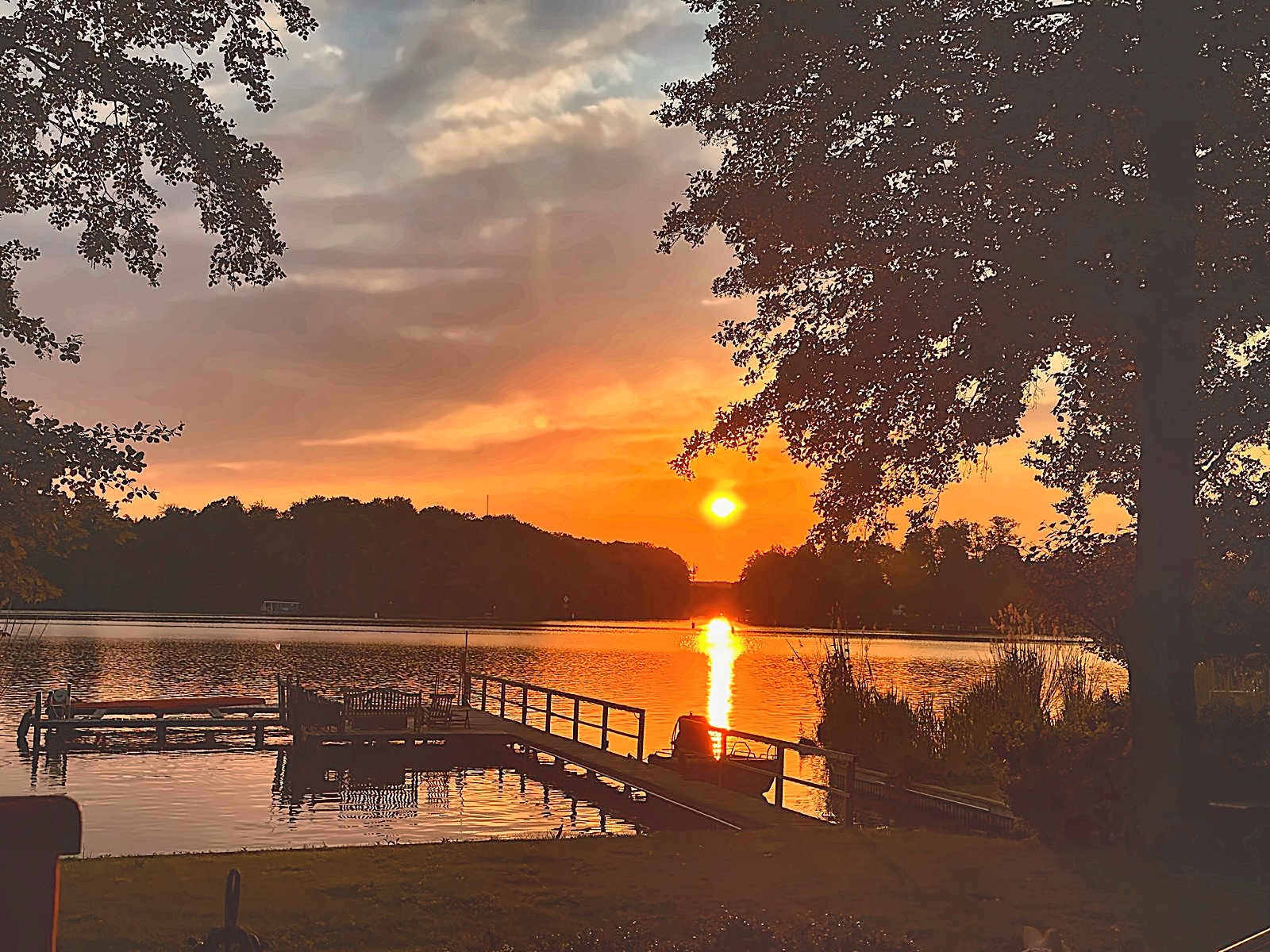Sonnenuntergang über dem Krüpelsee mit der Silhouette des eigenen Stegs